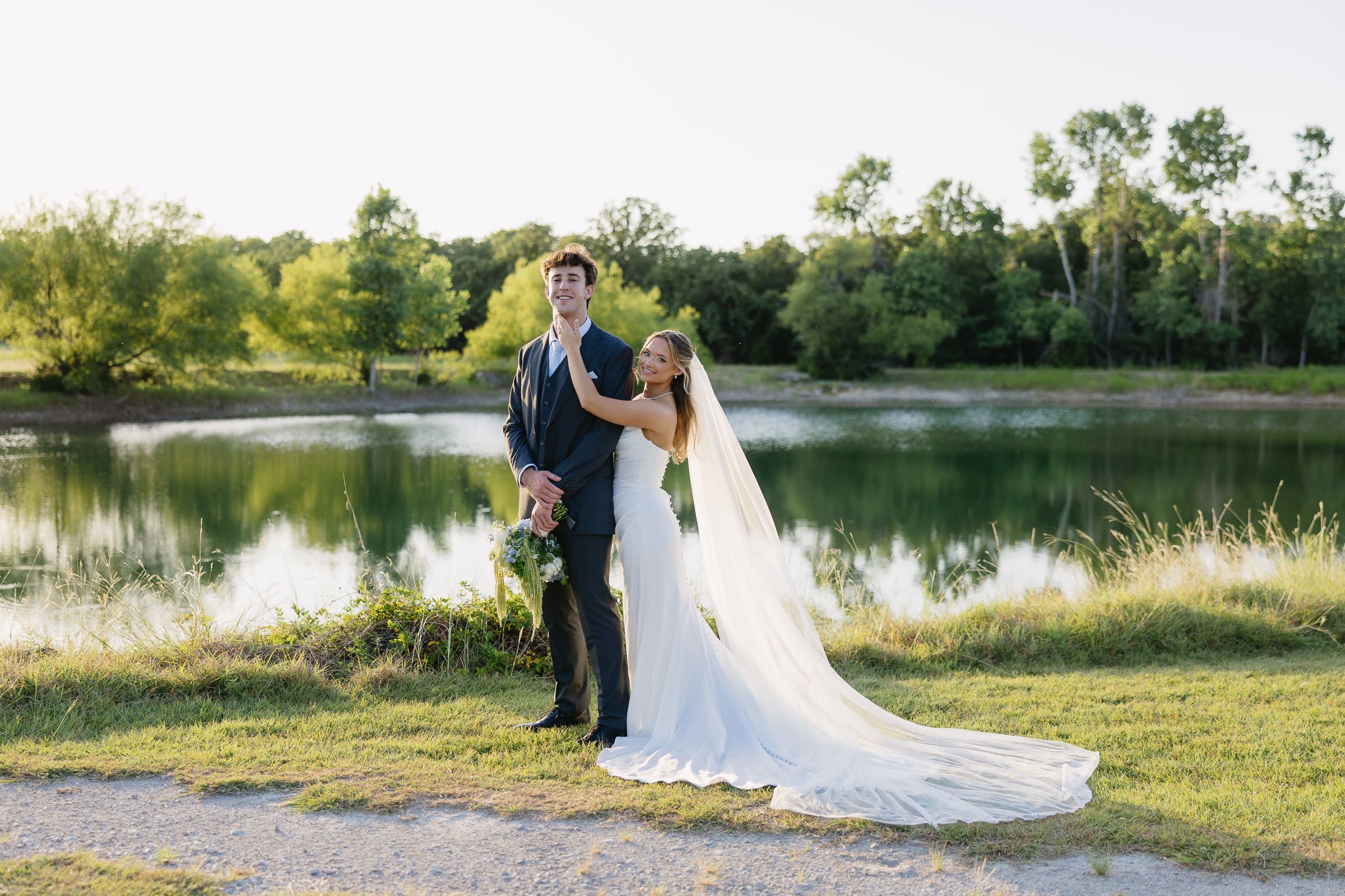 Bride and groom by the pond at The Barn at Paradise Place in Paradise, Texas