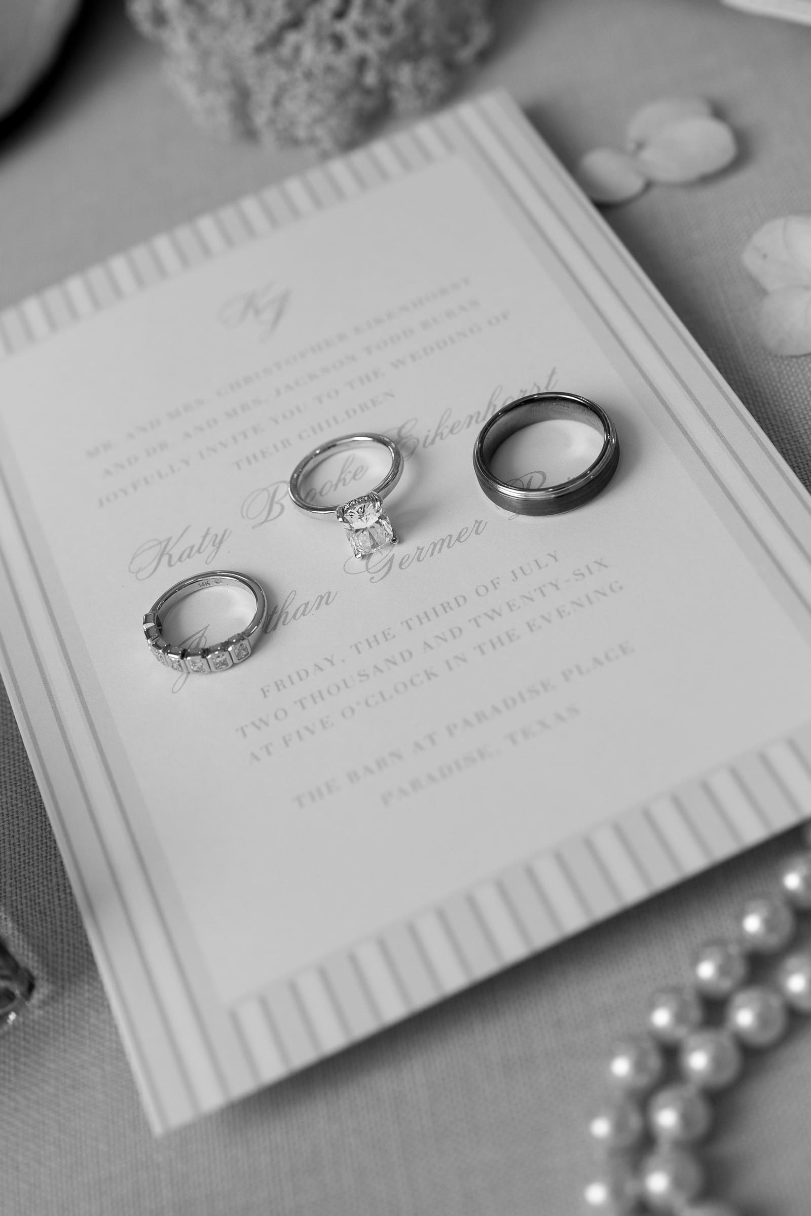 Wedding rings resting on the invitation suite at The Barn at Paradise Place