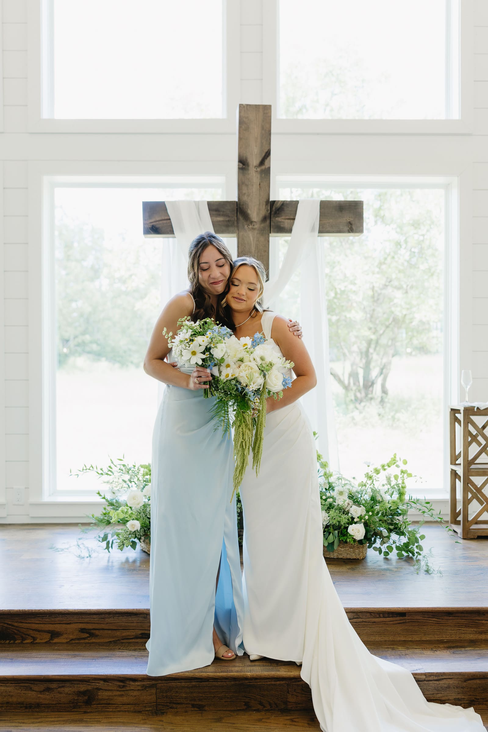 Bride sharing a joyful moment with a bridesmaid during wedding party portraits