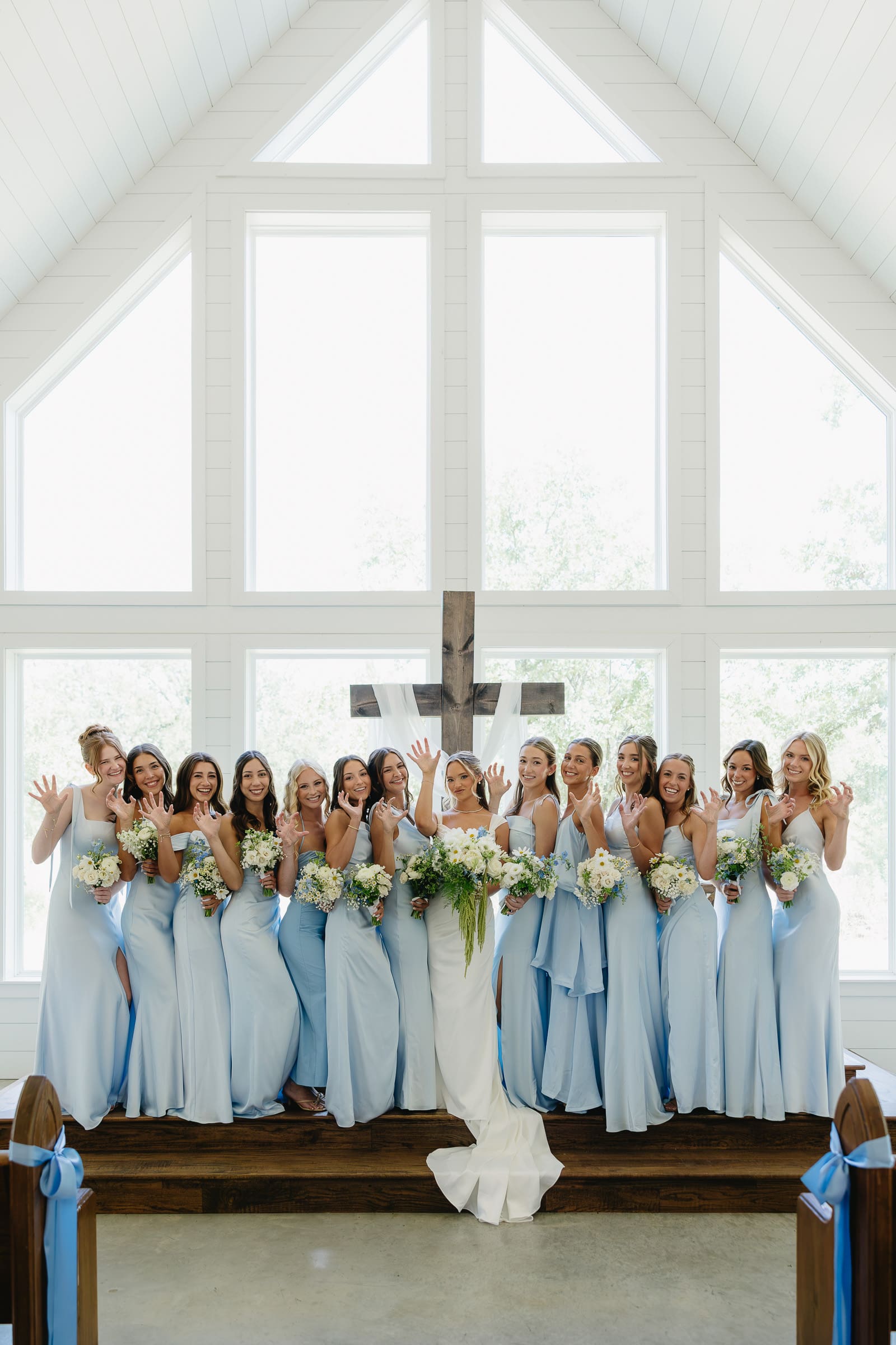 Bride and bridesmaids doing the Sic ’Em Bears hand sign during wedding party portraits