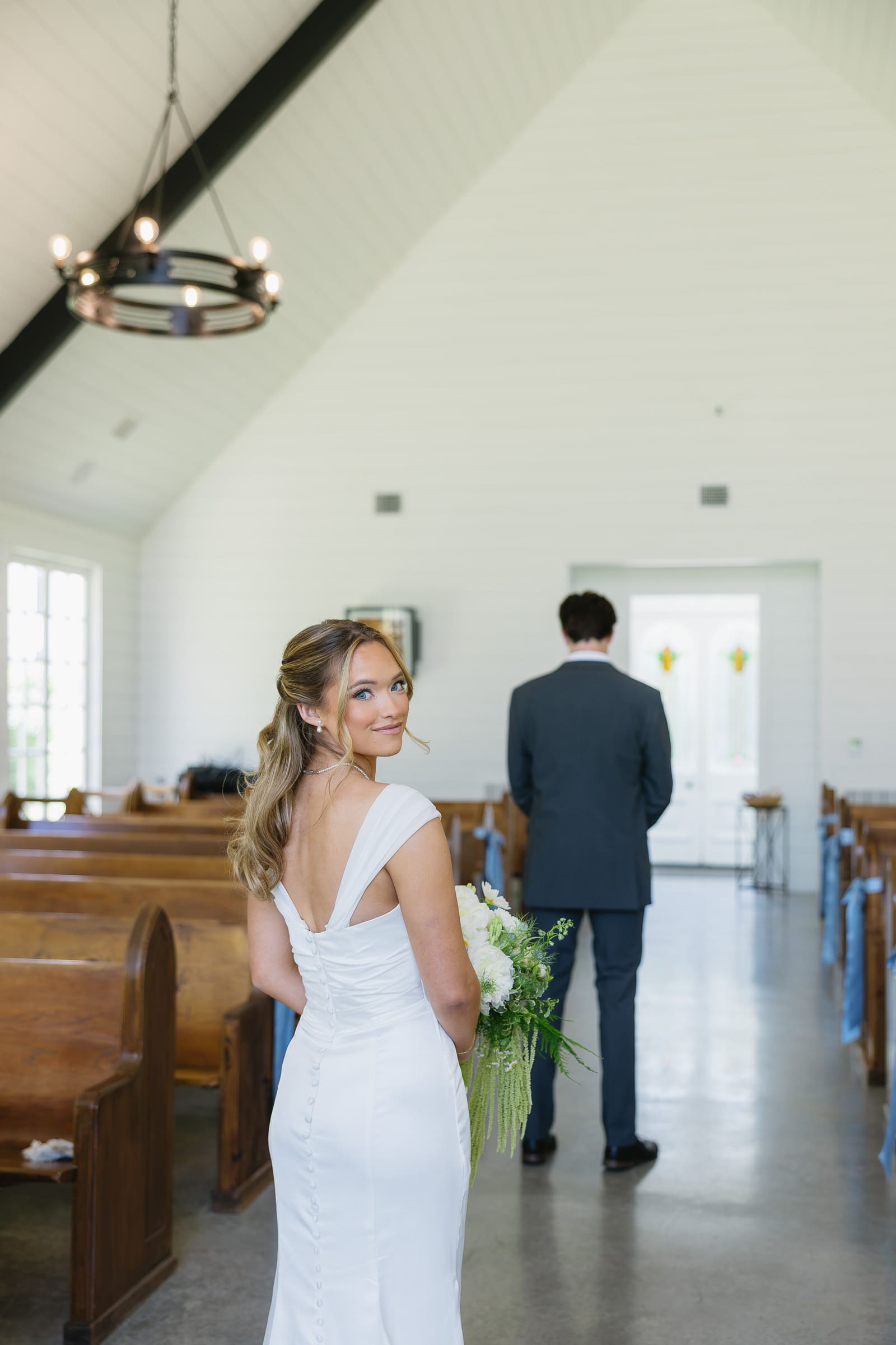 Bride looking back inside the chapel moments before her first look with the groom