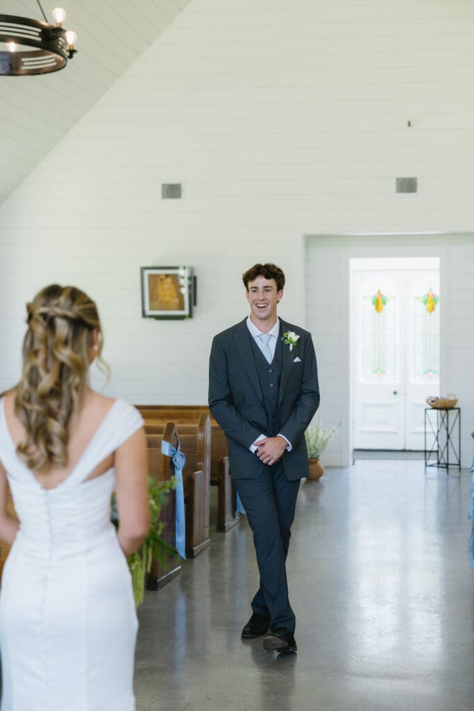 Groom seeing the bride for the first time during their first look in the chapel