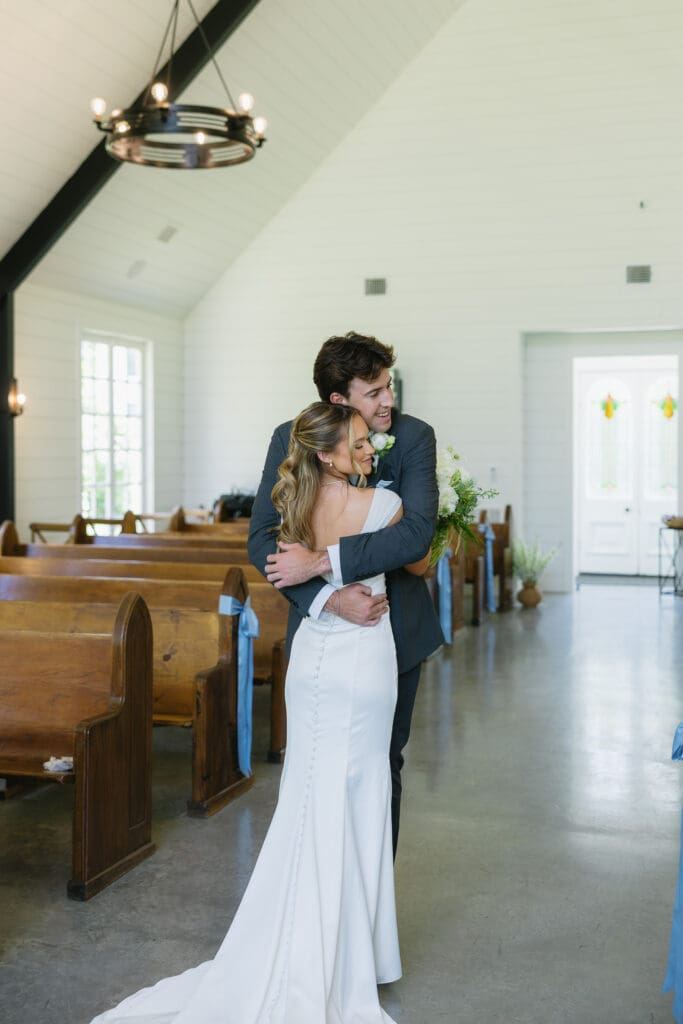 Bride hugging the groom inside the chapel at The Barn at Paradise Place