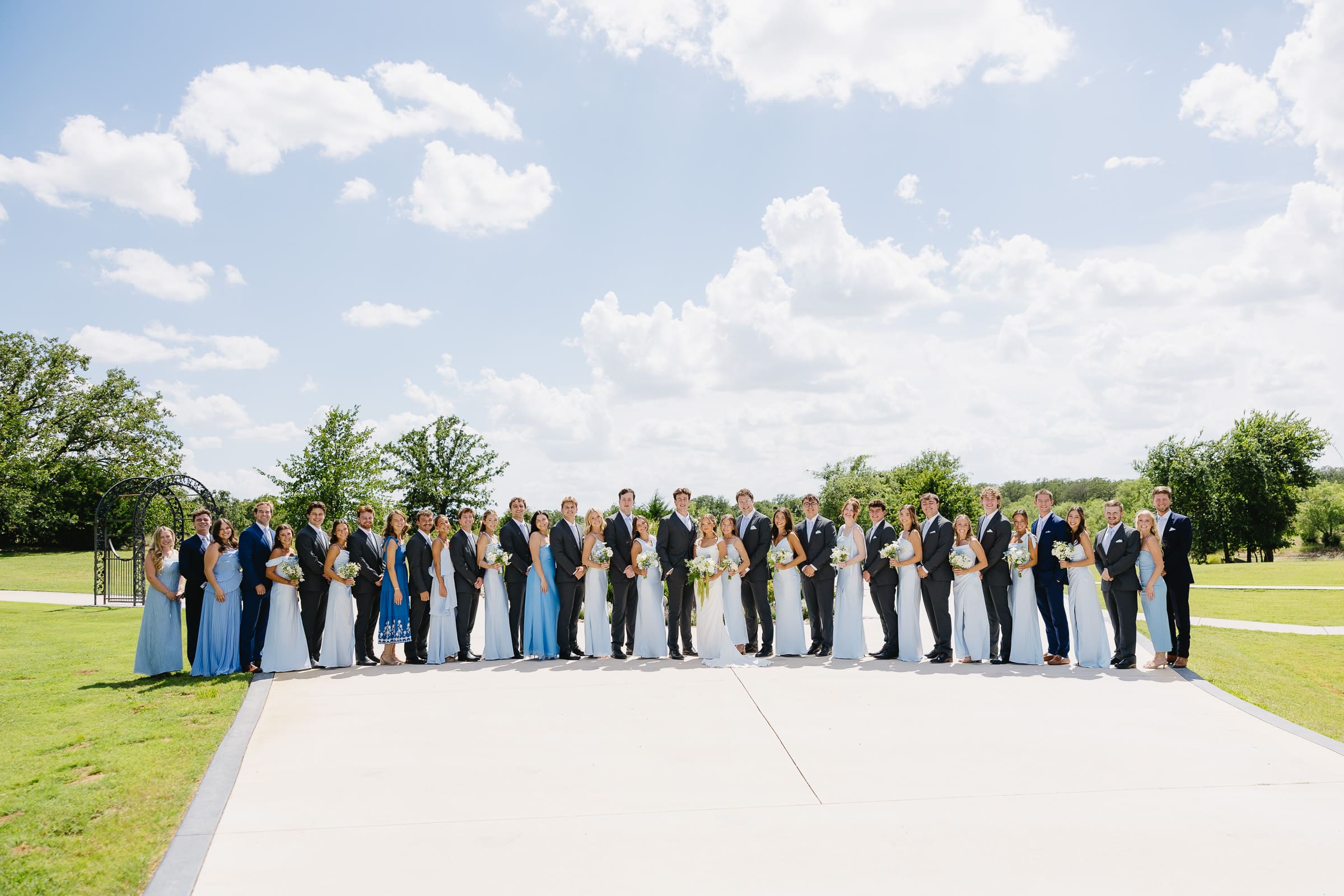 Bride and groom with their full wedding party outside The Barn at Paradise Place in Paradise, Texas