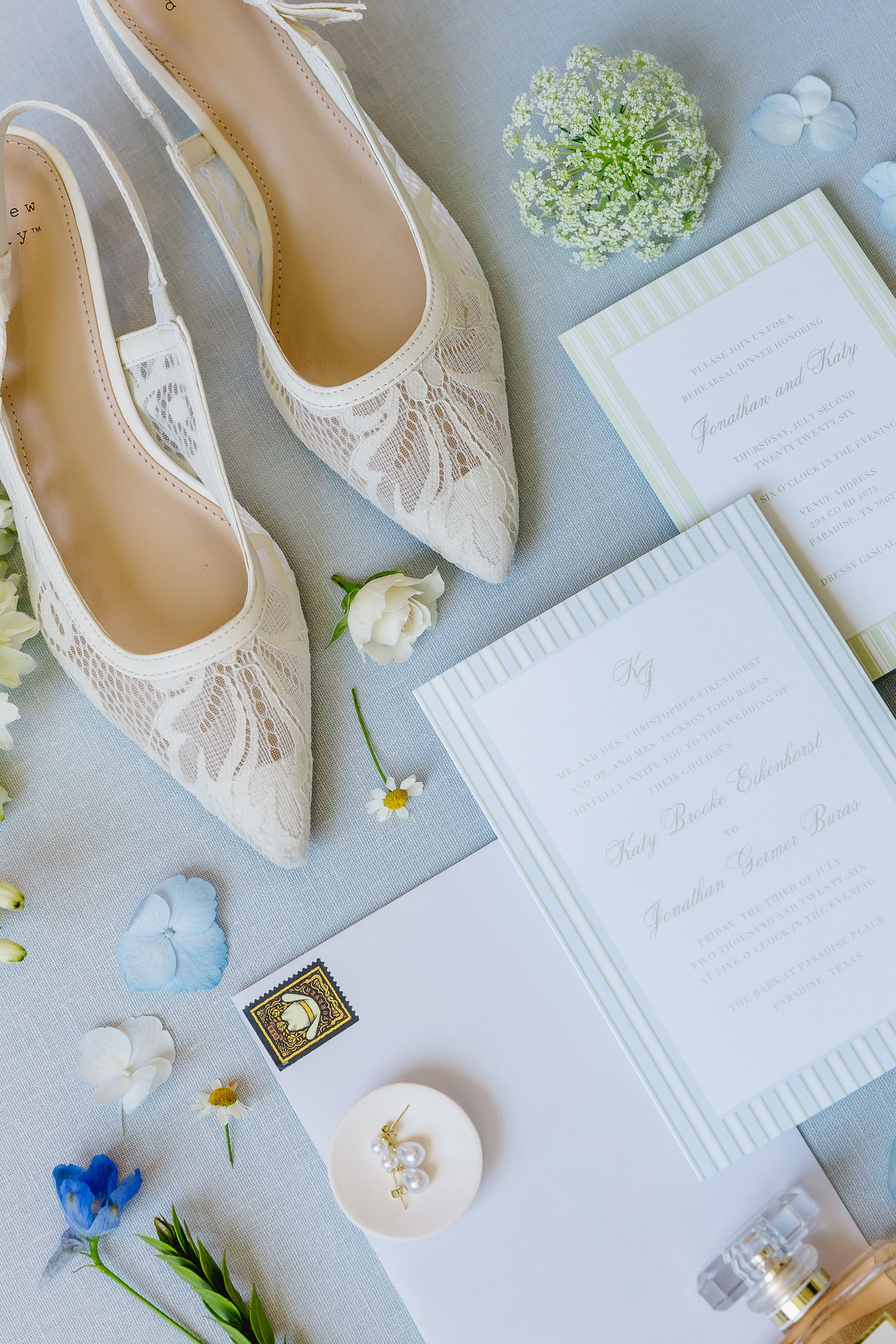 Bridal shoes and blue wedding invitation details for a summer wedding at The Barn at Paradise Place
